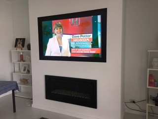 Wall Mounted TV above recessed gas fireplace by Jim's Antennas