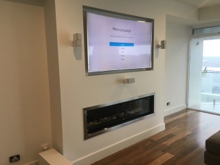 Gas log fire place with Wall Mounted TV above by Jim's Antennas