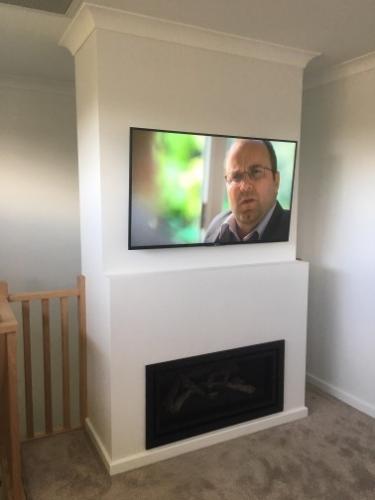 TV Mounted on Wall above Fireplace by Jim's Antennas
