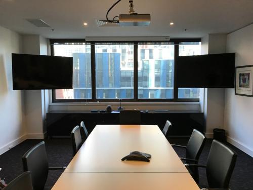 Dual screens mounted on movable arms in boardroom by Jim's Antennas